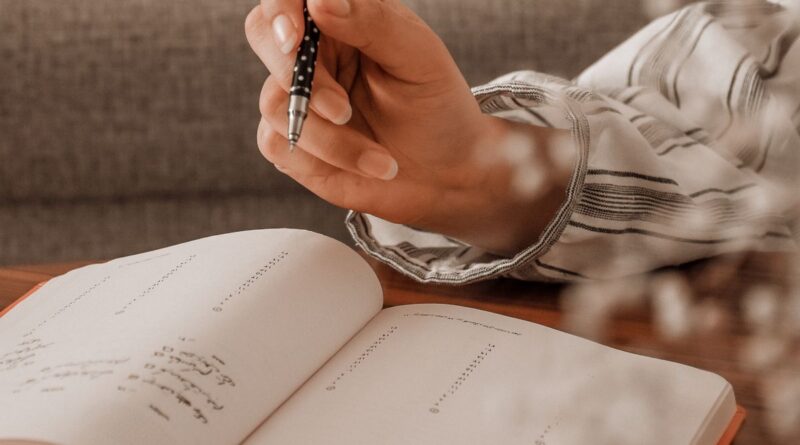 Student writing scholarship and job application deadlines into a personal organizer